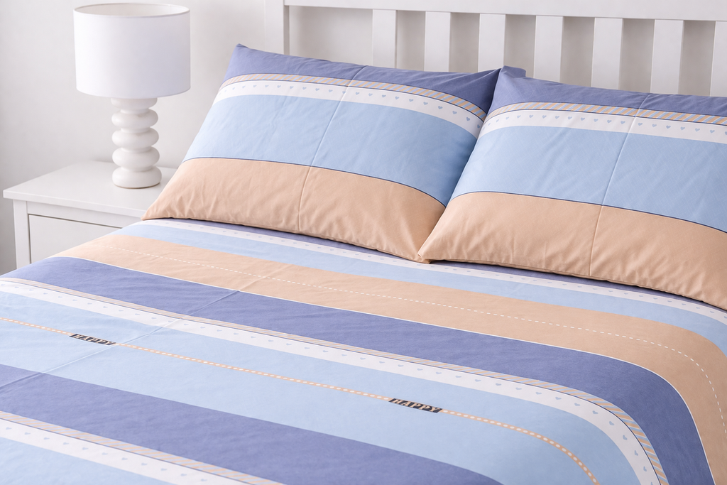 Striped bedding with blue and beige colors on a bed with a white headboard.