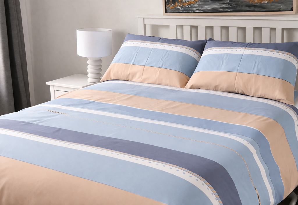 Striped bedspread with blue and beige colors on a bed in a bedroom setting.