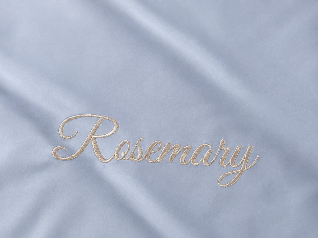 Embroidered name 'Rosemary' on a light blue sateen cotton sheet