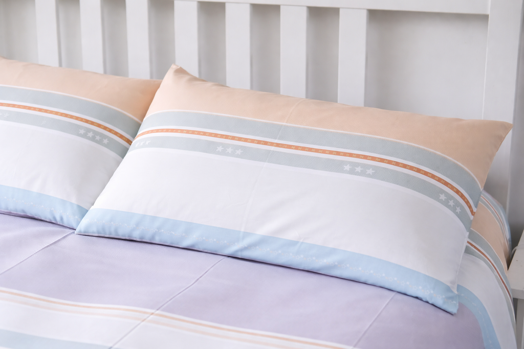 Striped pillows on a bed with a white headboard